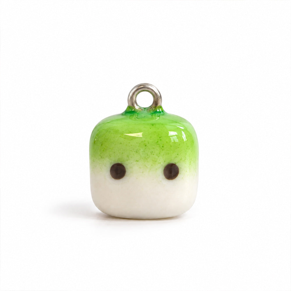 Handgemachter Matcha Mallow Clay Charm in Grün und Weiß vor hellem Hintergrund