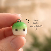 Nahaufnahme eines kleinen Matcha Clay Charms mit Metallöse